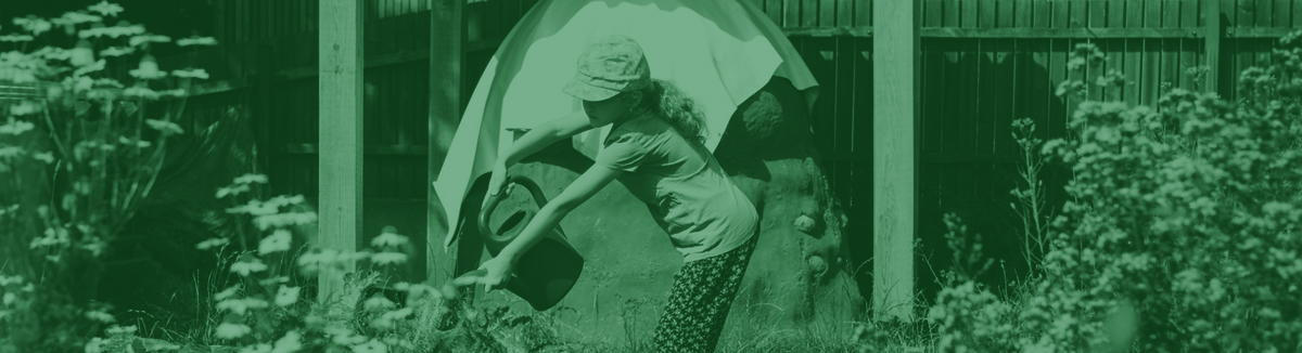 Obrazek, przedstawia widok wspolnego ogrodu, dziewczynka polewa grządki.