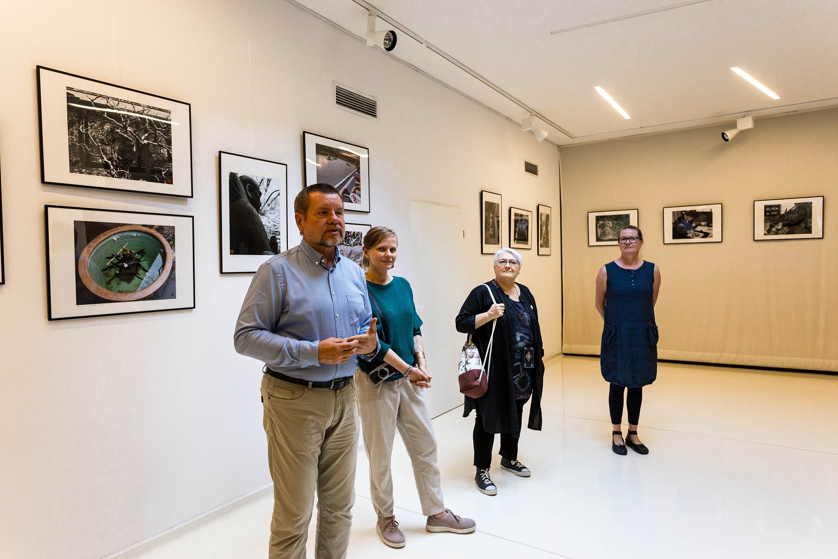 Widok Galerii w SDK podczas wernisażu wystawy ZEN, na ścianach prezentowane są fotografie. Na zdjęciu widzimy Jacka M.Kmieciaka, autora prac, Nel Lato koordynatorkę wystawy, Barbara Czekańską współkoordynatorkę wystawy, i Agnieszkę Kmieciak, autorkę wystawy.