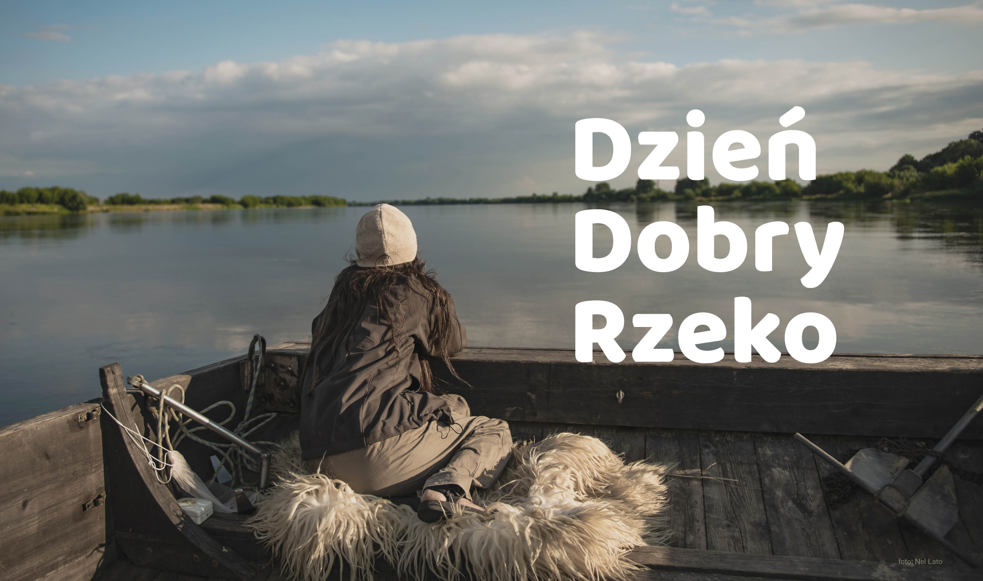 Zdjęcie ilustruje artykuł Światowy Dzień Rzek, przedstawia osobę siedzącą na łodzi która znajduje się na rzece. Osobę widzimy od tyłu, osoba spogląda przed siebie na panoramę spokojnej rzeki. Na zdjęciu biały napis Dzień Dobry Rzeko, foto Nel Lato