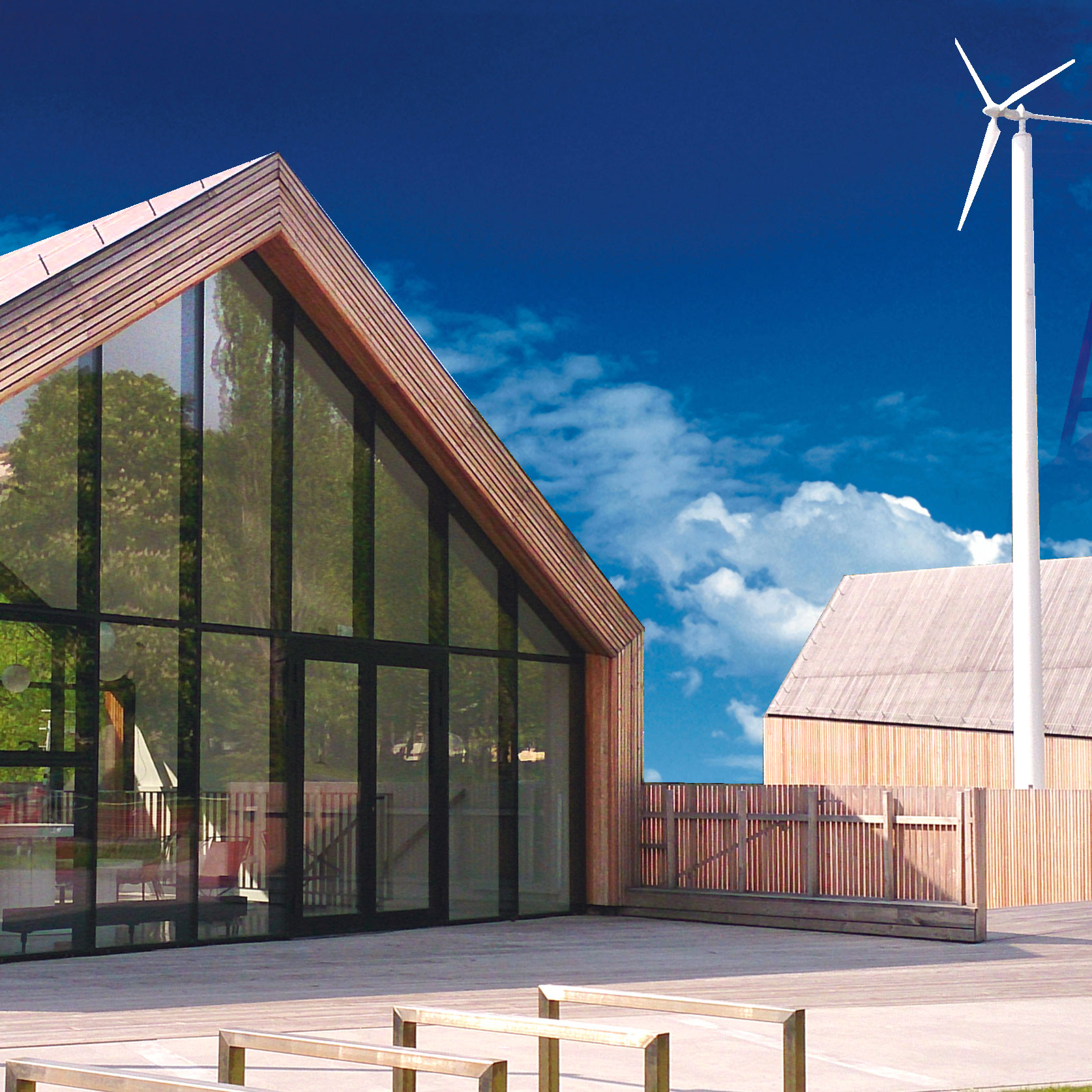 Na zdjęciu widać drewniany budynek sdk, budynek przypomina wiejską zagrodę, w tle intensywnie niebieskie niebo w słoneczny dzień.