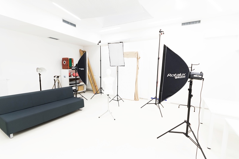 Zdjęcie siedziby SDK Na zdjęciu pracownia foto. Widoczne oświetlenie studyjne, tło fotograficzne oraz inny sprzęt fotograficzny.