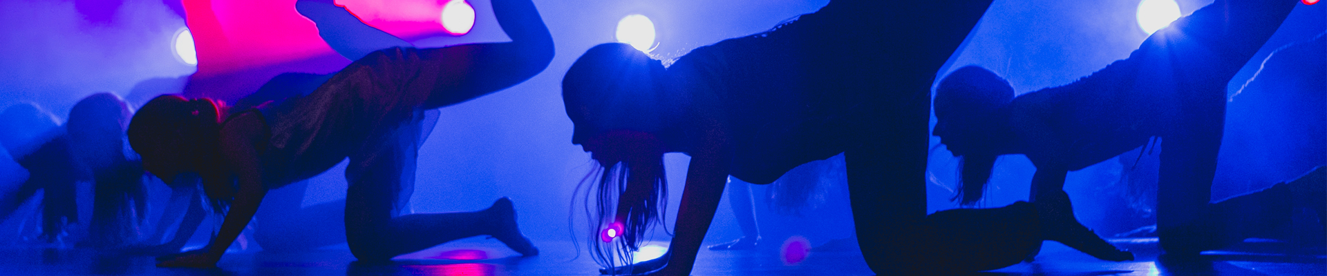 Na zdjęciu widoczne postacie tancerek na scenie w zbliżeniu. 