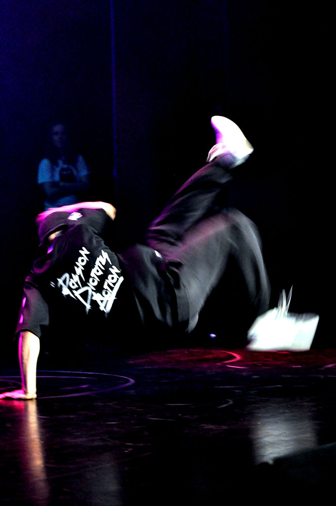 Na zdjęciu widoczny jest tancerz break dance w akrobatycznej pozycji. 