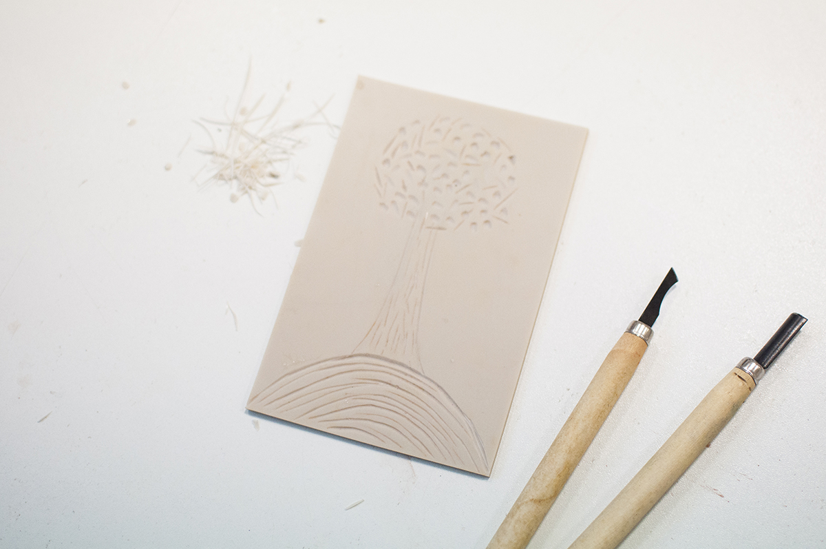 Na zdjęciu widoczna jest praca uczestnika warsztatów oraz narzędzia służące do jej wykonania. Płaskorzeźba oraz narzędzia. 