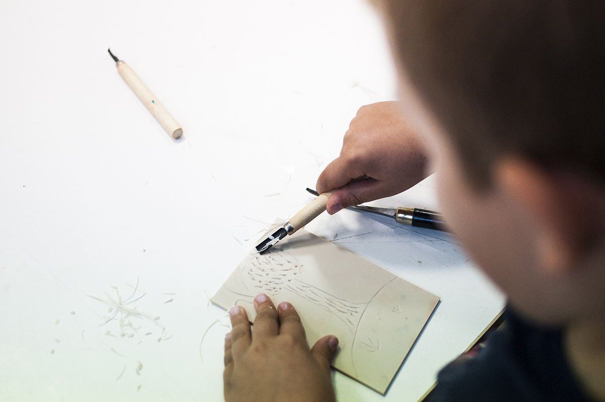 Zdjęcie promocyjne pracowni Na zdjęciu znajduje się chłopiec wykonujący płaskorzeźbę.