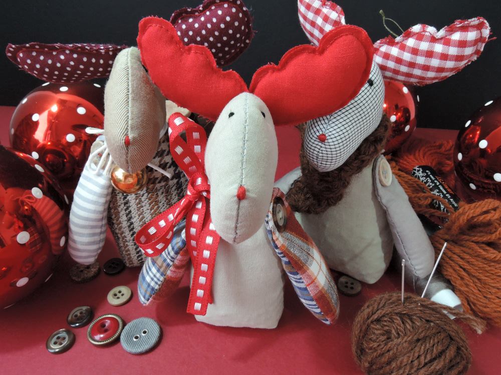 Zdjęcie promocyjne pracowni. Na zdjęciu trzy uszyte misie renifery wśród bombek, wełny i guzików.