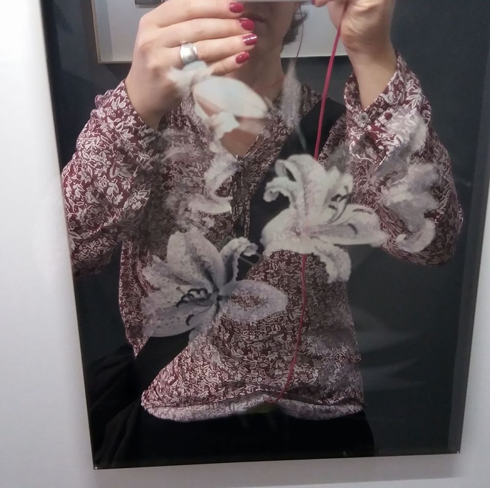 Na zdjęciu widać autoportret wykonany przed lustrem, z niewidoczną twarzą. Ostrość pada na ozdoby wykonane na lustrze oraz na pstrokatą bluzę,