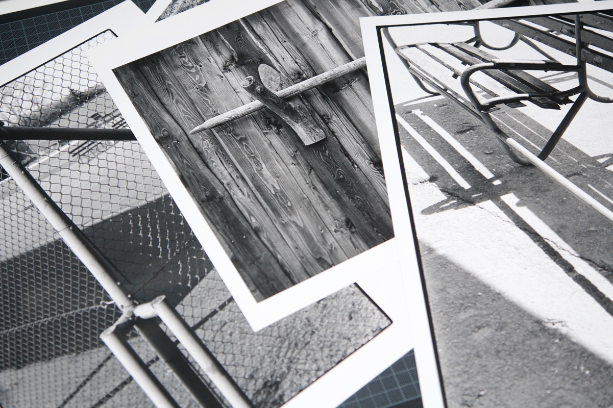 Rozłożone na stole monochromatyczne zdjęcia analogowe