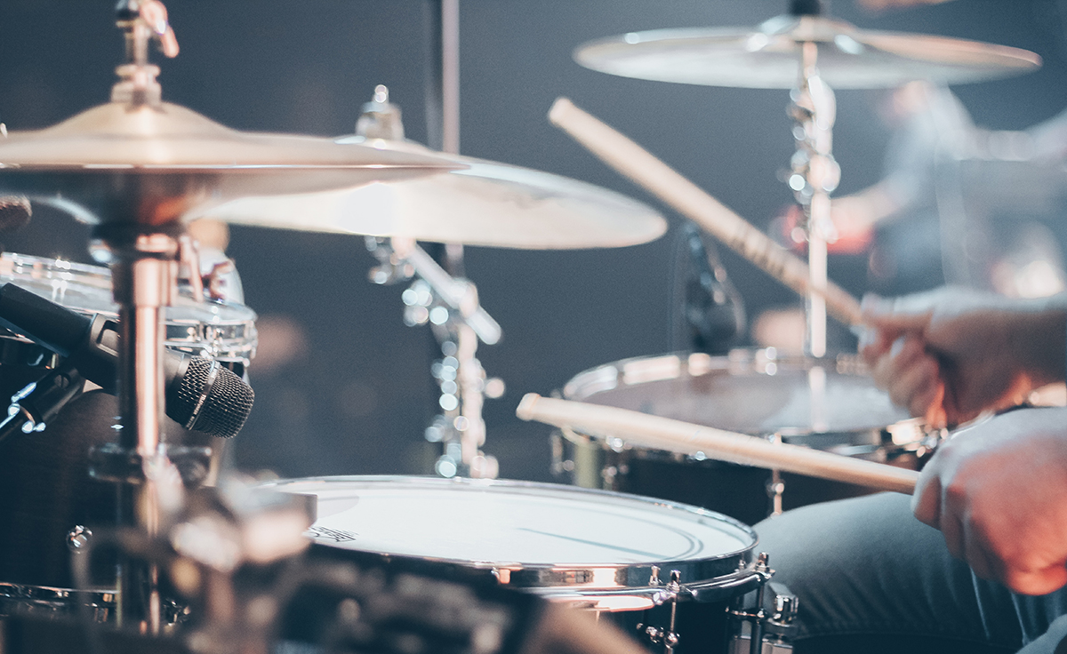 Zdjęcie promocyjne pracowni. Serwis PEXELS.com Zdjęcie przedstawia perkusję oraz fragment dłoni osoby grającej na niej.
