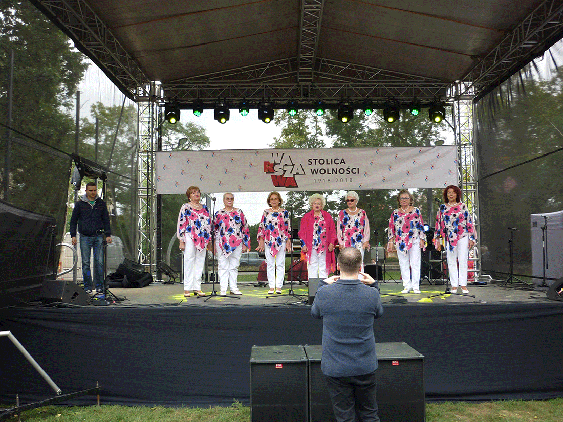 Zdjęcie promocyjne zespołu Kolejny koncert Służewianek. Wokalistki stoją na plenerowej scenie.