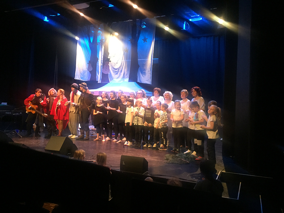 Służewianki na scenie po koncercie. Wspólne zdjęcie z artystami. Pełna scena występujących artystów. 