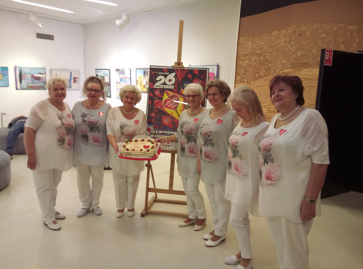 Zdjęcie promocyjne zespołu. Służewianki prezentują tort, który przygotowały na aukcję 26. finału WOŚP