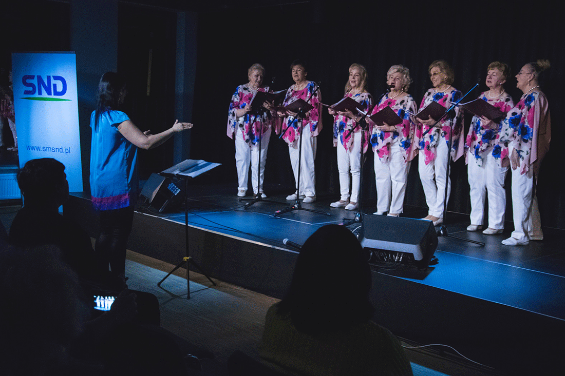 Zdjęcie promocyjne zespołu Na zdjęciu Służewianki na scenie podczas próby. Przed sceną instruktorka.