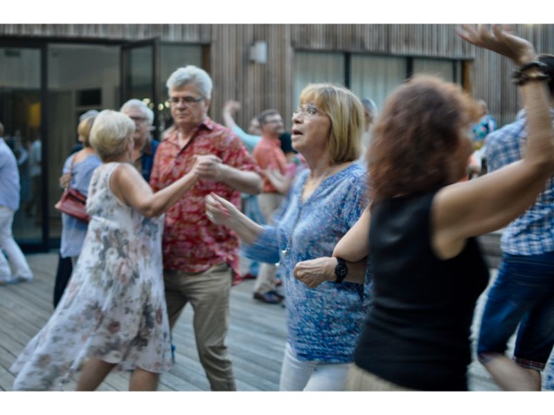 Pary tańczące do muzyki retro. W tle budynek SDK