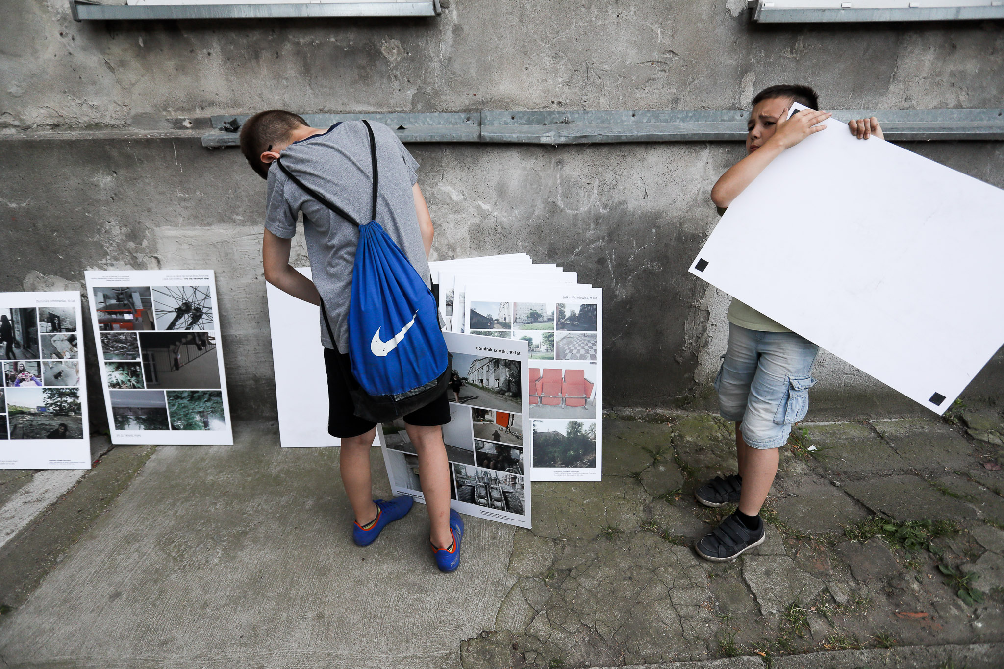 Wernisaż wystawy "Moje podwórko. Mój dom - Praga oczami dzieci" - na zdjeciu dzieci rozwieszają swoje zdjęcia.