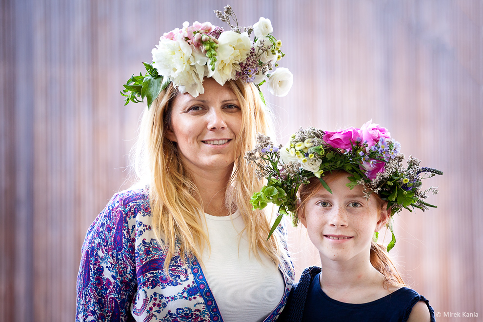 Zdjęcie przedstawia kobietę  i dziewczynkę w wiankach. W tle widzimy deski amfiteatru SDK.