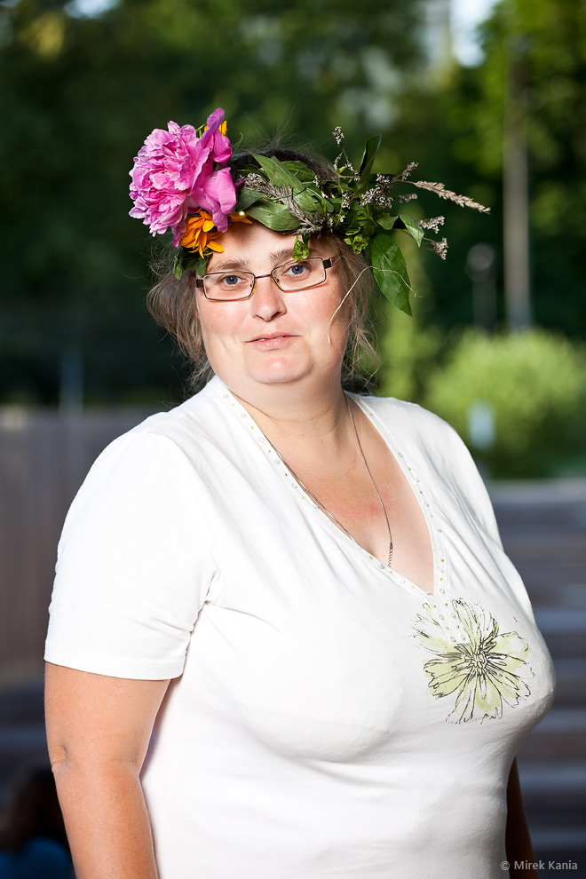 Na zdjęciu widoczna jest kobieta  w wianku. W tle widoczny jest Park SDK