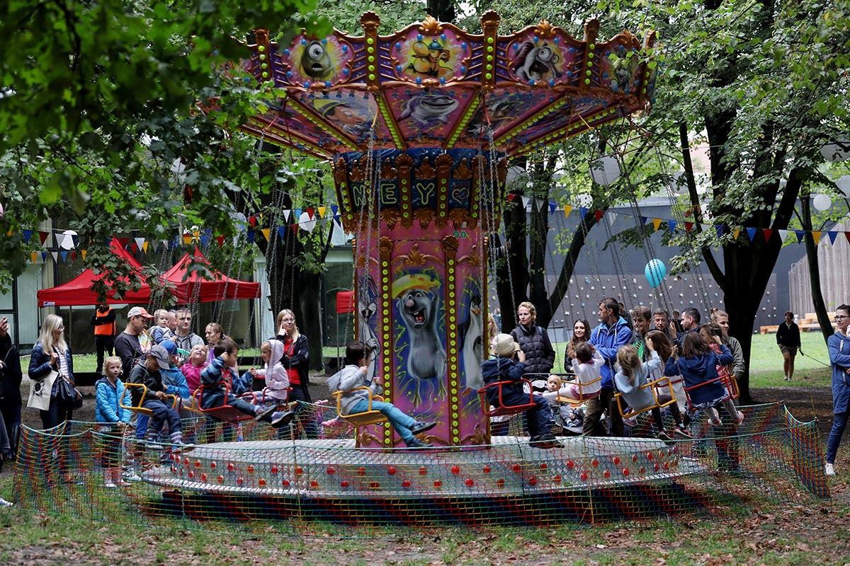 Na zdjęciu karuzela z gośćmi pikniku urodzinowego SDK. W tle namioty urodzinowe oraz zielone liście drzew. Foto: Sławomir Kamiński.