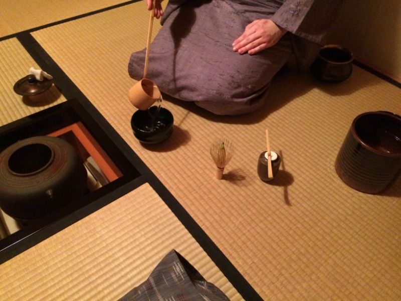 Grafika przedstawia zbliżenie na fragment ceremoniału picia herbaty.