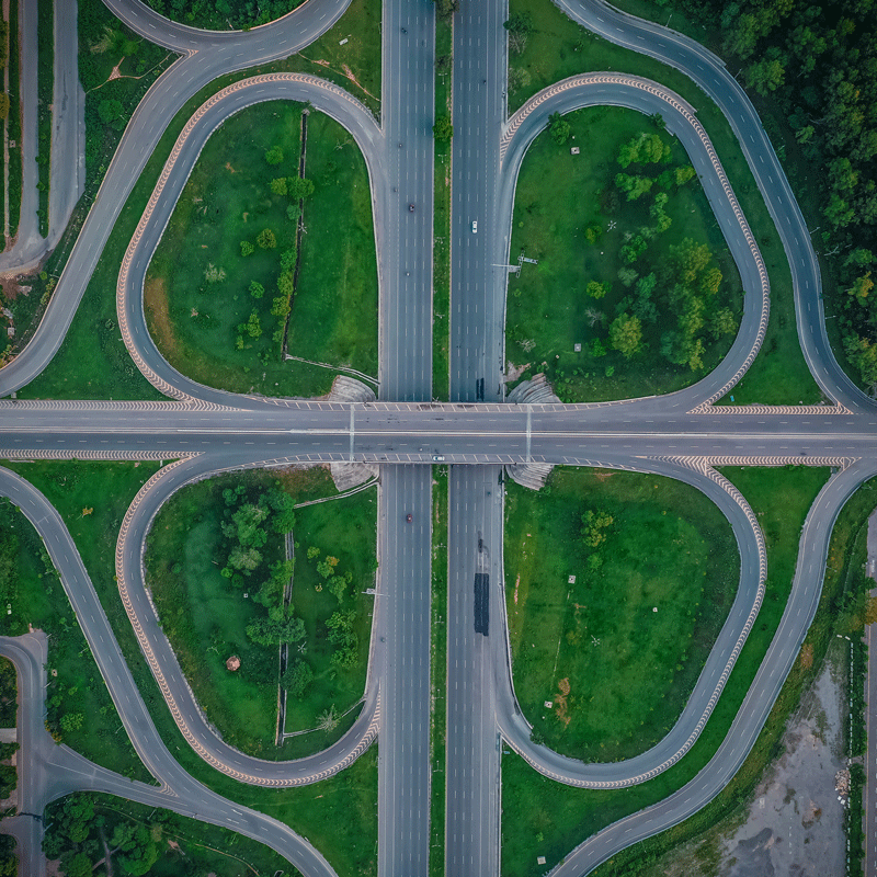 Na zdjęciu znajduje się skrzyżowanie dróg widoczne z lotu ptaka. Duży węzeł komunikacyjny.