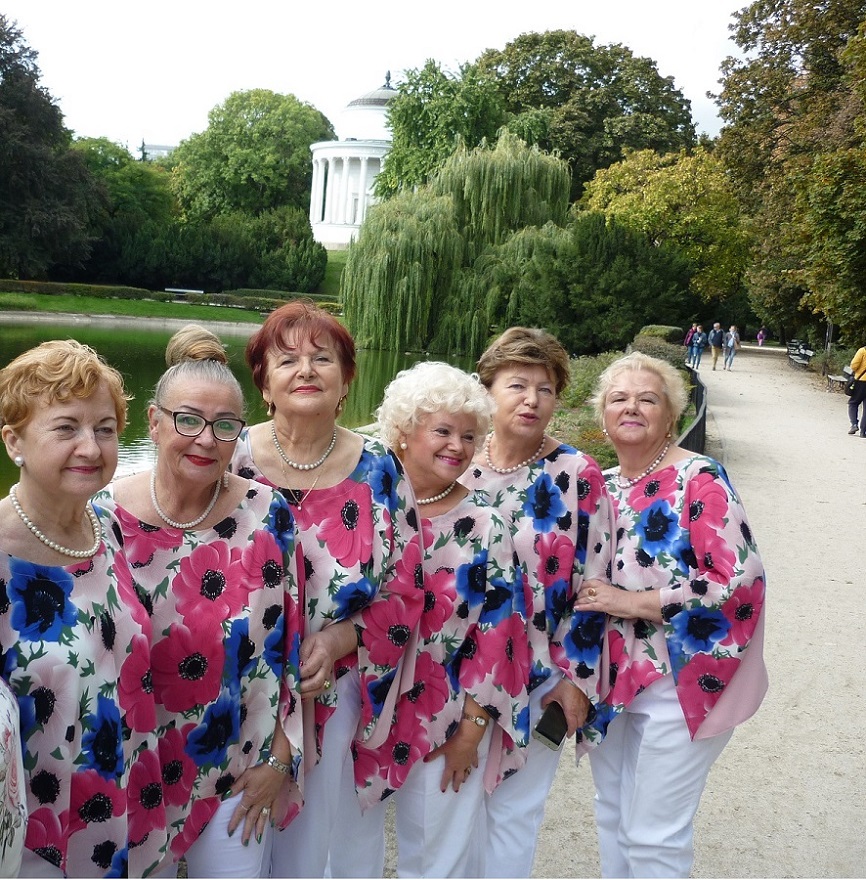 Na zdjęciu wokalistki zespołu Służeiwanki - ubrane w białe spodnie i kwieciste luźne tuniki. W tle Ogród Saski