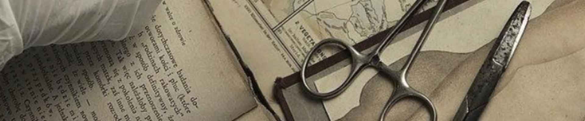 Dłoń w chirurgicznej rękawiczce rozchylająca części rozerwanej mapy. Fragment okładki książki "Dzieci Louisa"