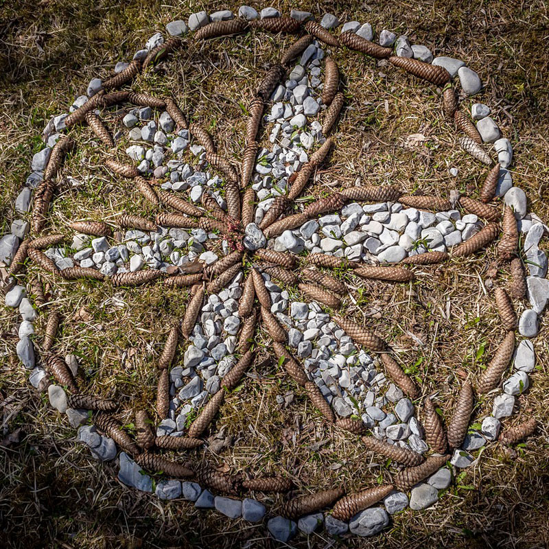 Na zdjęciu wzór w okręgu ułożony z szyszek i kamieni. Foto: Za pixaby/domena publiczna