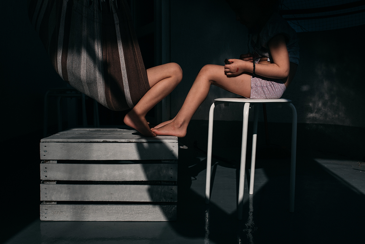 Rama namalowana światłem: w ostrym słońcu na balkonie w hamakach siedzą dwie kilkulatki, widzimy to w obrysie z bardzo głębokiego cienia. Fot. Agnieszka Mocarska