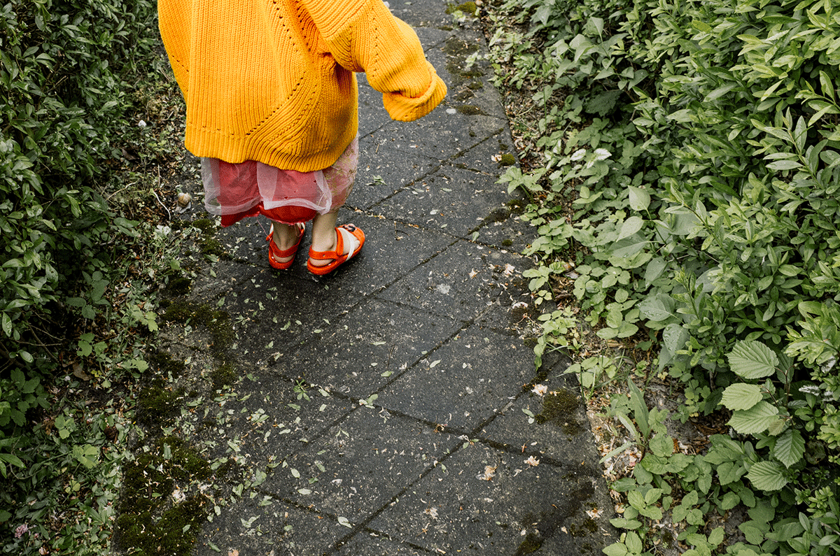 Na zdjęciu widać połowę korpusu 5-letniej dziewczynki w lewym, górnym rogu skaczącej na chodniku. fot. Zuzanna Jach
