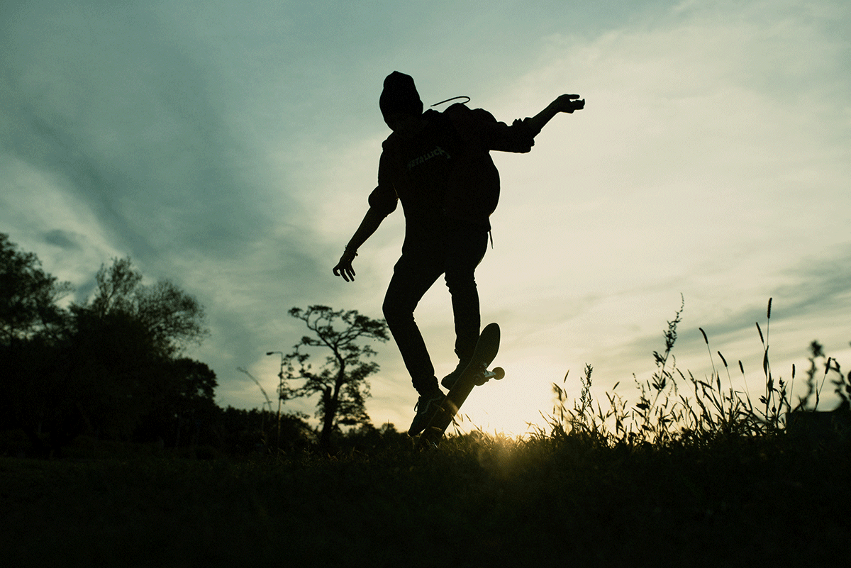 Na zdjęciu występuje zarys sylwetki nastoletniego chłopca jeżdżącego na deskorolce. Fot. Agnieszka Mocarska