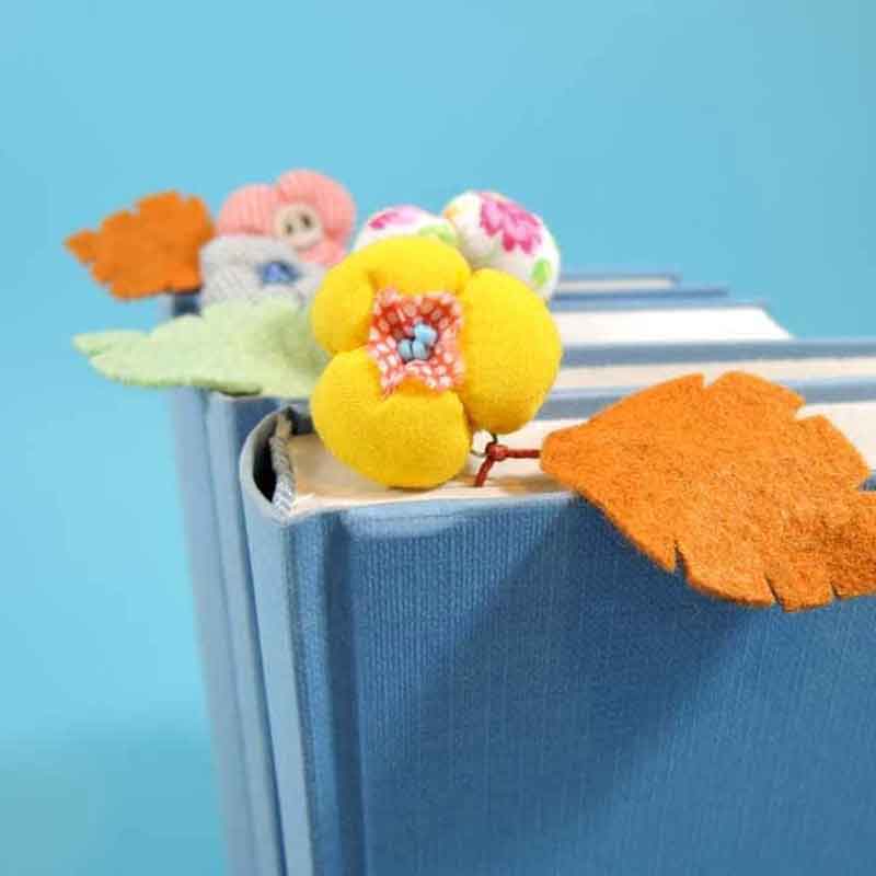 Zdjęcie książek z zakładkami w formie filcowych kwiatów