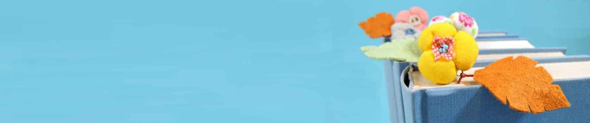 Zdjęcie książek z zakładkami w formie filcowych kwiatów