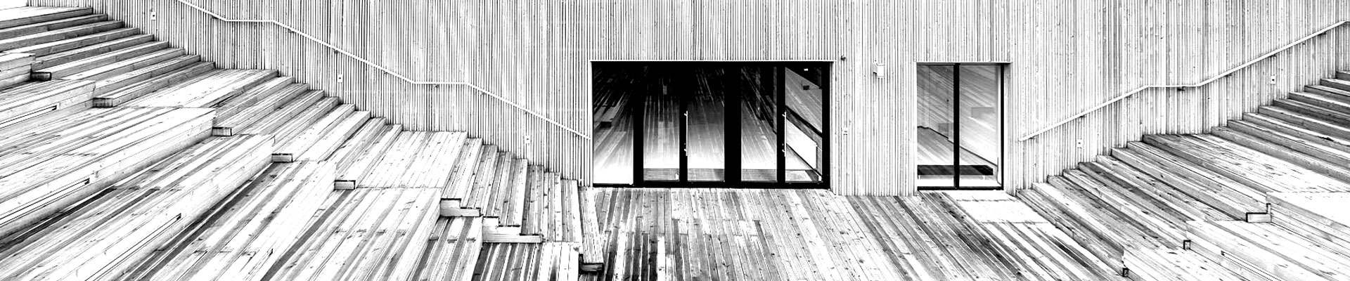 Na zdjęciu fragment architektury SDK. Drewniany amfiteatr oraz wejście główne do budynku SDK. Zdjęcie czarno-białe. 