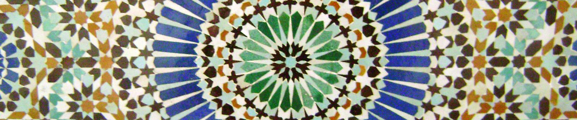 Zdjęcie fragmentu mozaiki ułożonej centalnie w okręgi z geometrycznych elementów.
