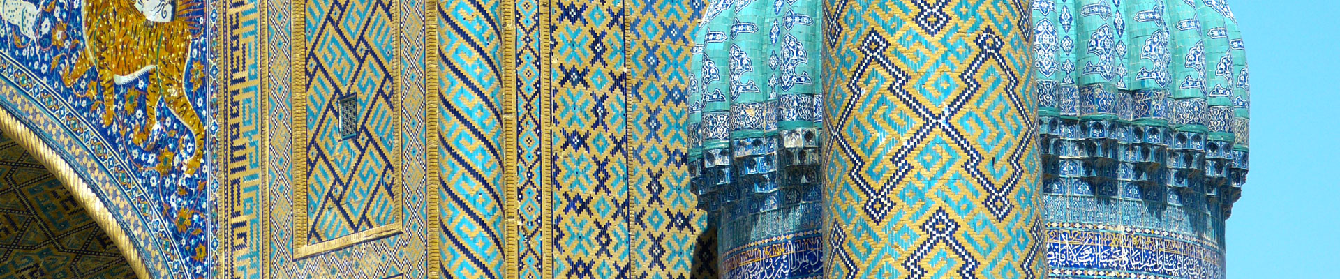 NA zdjęciu fragmenty budowli charakterystycznych dla Samarkandy. Kolorowe elewacje oraz dachy budynków. Przeważa kolor niebieski.