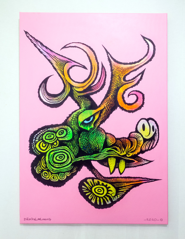 Stworzenie przypominające głową łosia. Abstrakcyjna forma, ostre i pokręcone rogi, ogon z oczami, dwa wystające zęby znajdują się na boku stworzenia. 